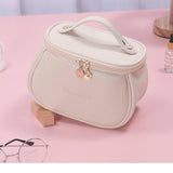 Trousse de maquillage blanc lait compacte posée sur une coiffeuse