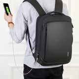 Homme rechargeant son téléphone sur le port USB de son sac à dos
